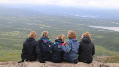 Bild på scouter som blickar ut över ett landskap.