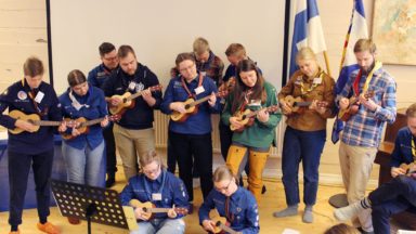 Scouter som spelar ukulele